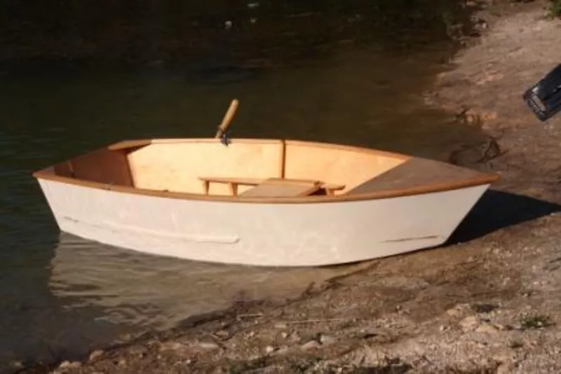 Одноместная гребная лодка с жестким корпусом.